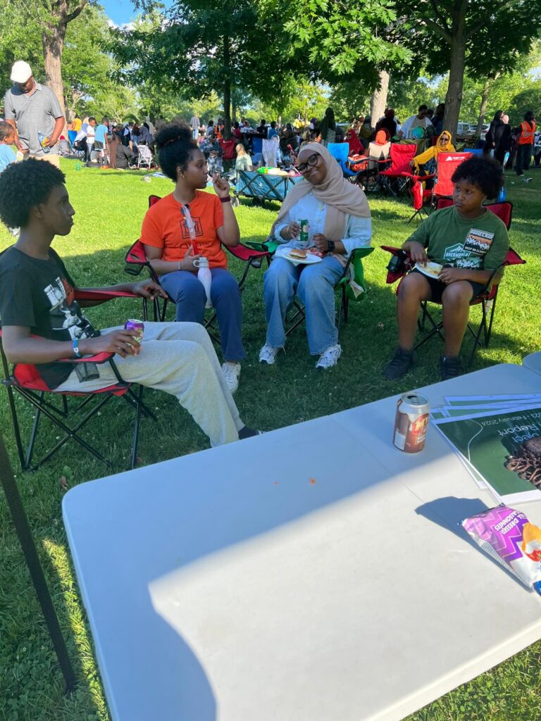 People seated together outdoors at a community gathering.