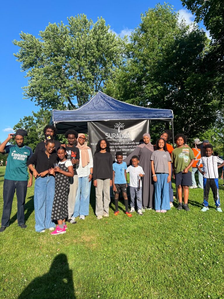 A group of people standing together under an outdoor event tent.