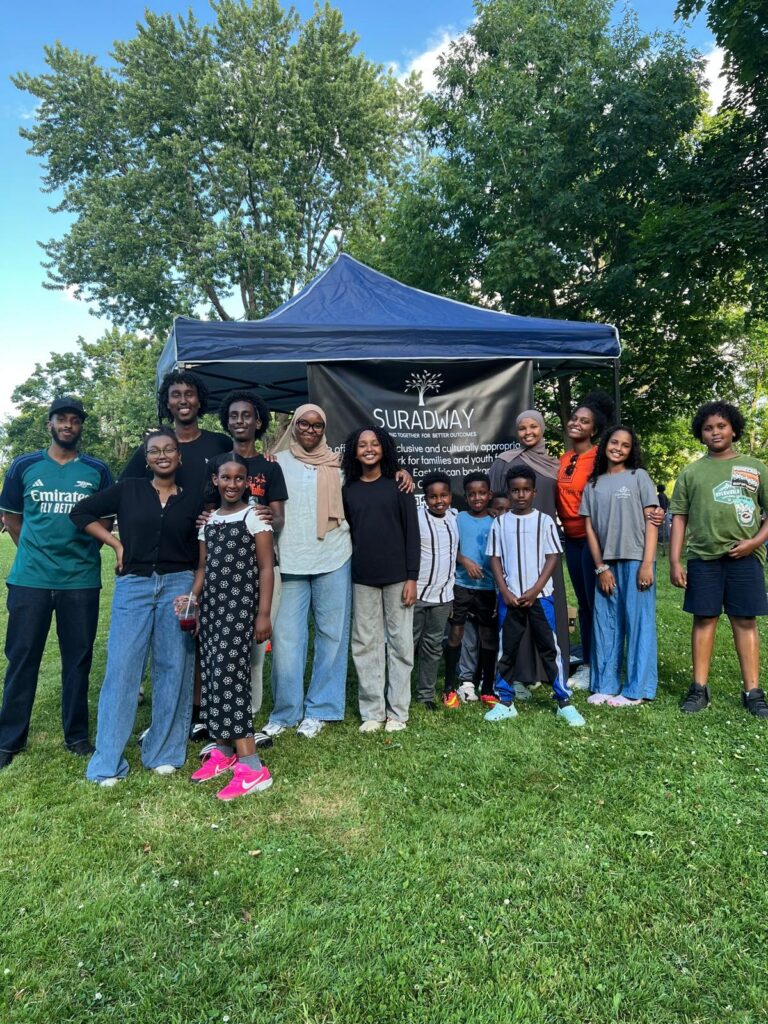 A large group of people posing together outdoors at a community event.